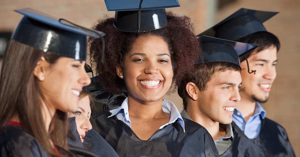 Five smiling college graduates who are happy to decrease their expenses with education tax credits.